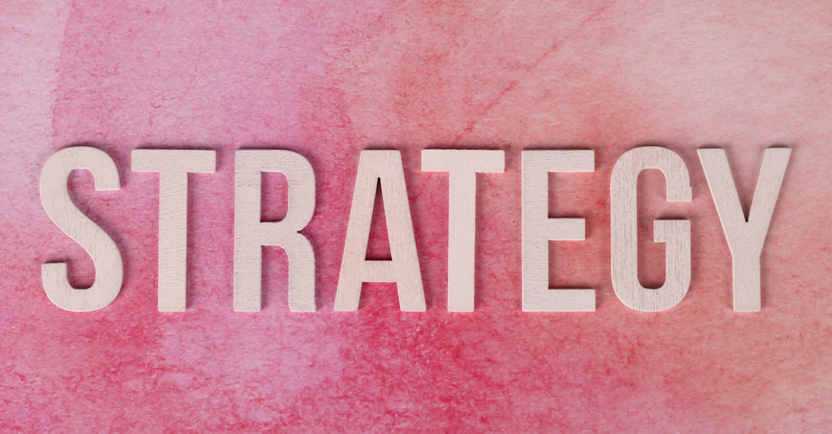 service-1 Wooden letters spelling 'Strategy' on a pink textured background.